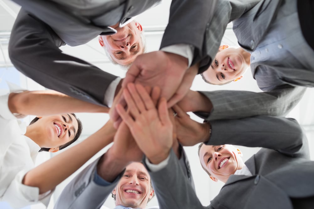 Business team standing hands together in the office Business team standing hands together in the office